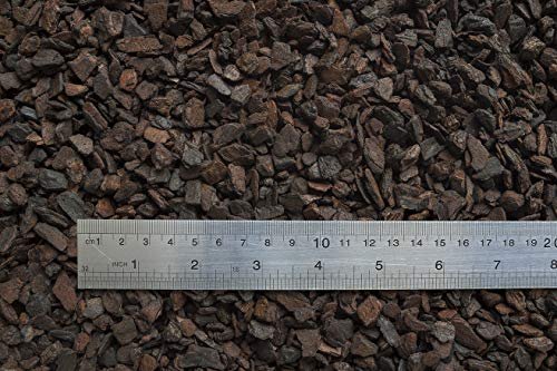 Orchiata - Close-up of small dark brown orchid bark pieces measured against a ruler showing centimeter and inch markings